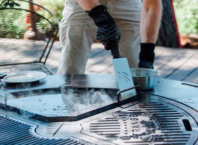 A man cleaning the firepit grill combo